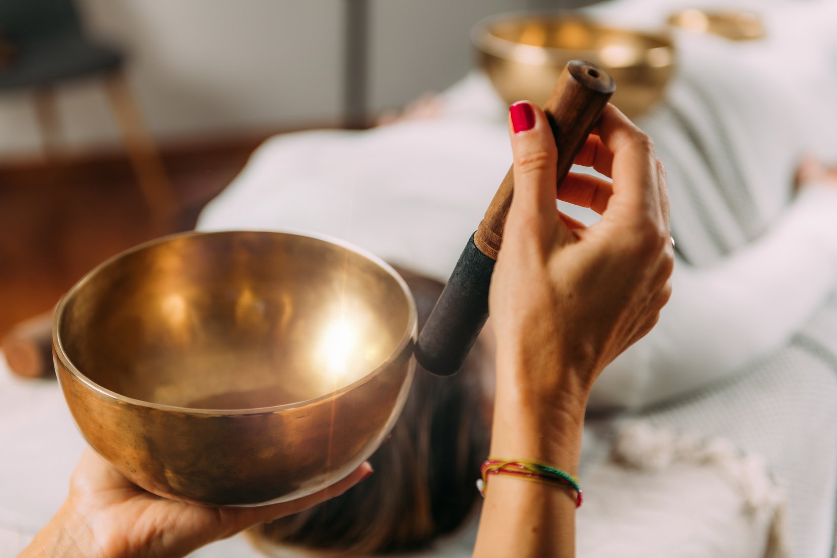 Woman Playing Tibetan Singing Bowl In Sound Healing Therapy